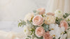 A high-end floral arrangement featuring blush pink peonies, creamy white garden roses, and cascading white orchids in an elegant ivory vase, captured with soft morning sunlight and a shallow depth of field.