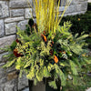 Jardinière extérieure d’hiver élégante composée de verdures fraîches, de branches de cornouiller jaune et de textures naturelles — une création signée McKenna Florist à Montréal.